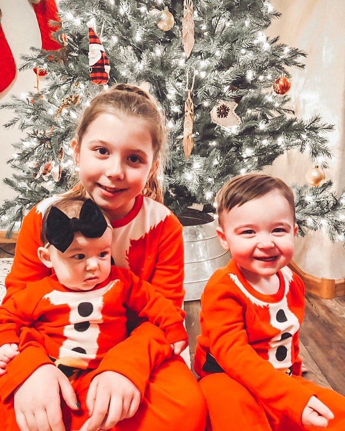 The 3 siblings celebrating Christmas with matching onesies.