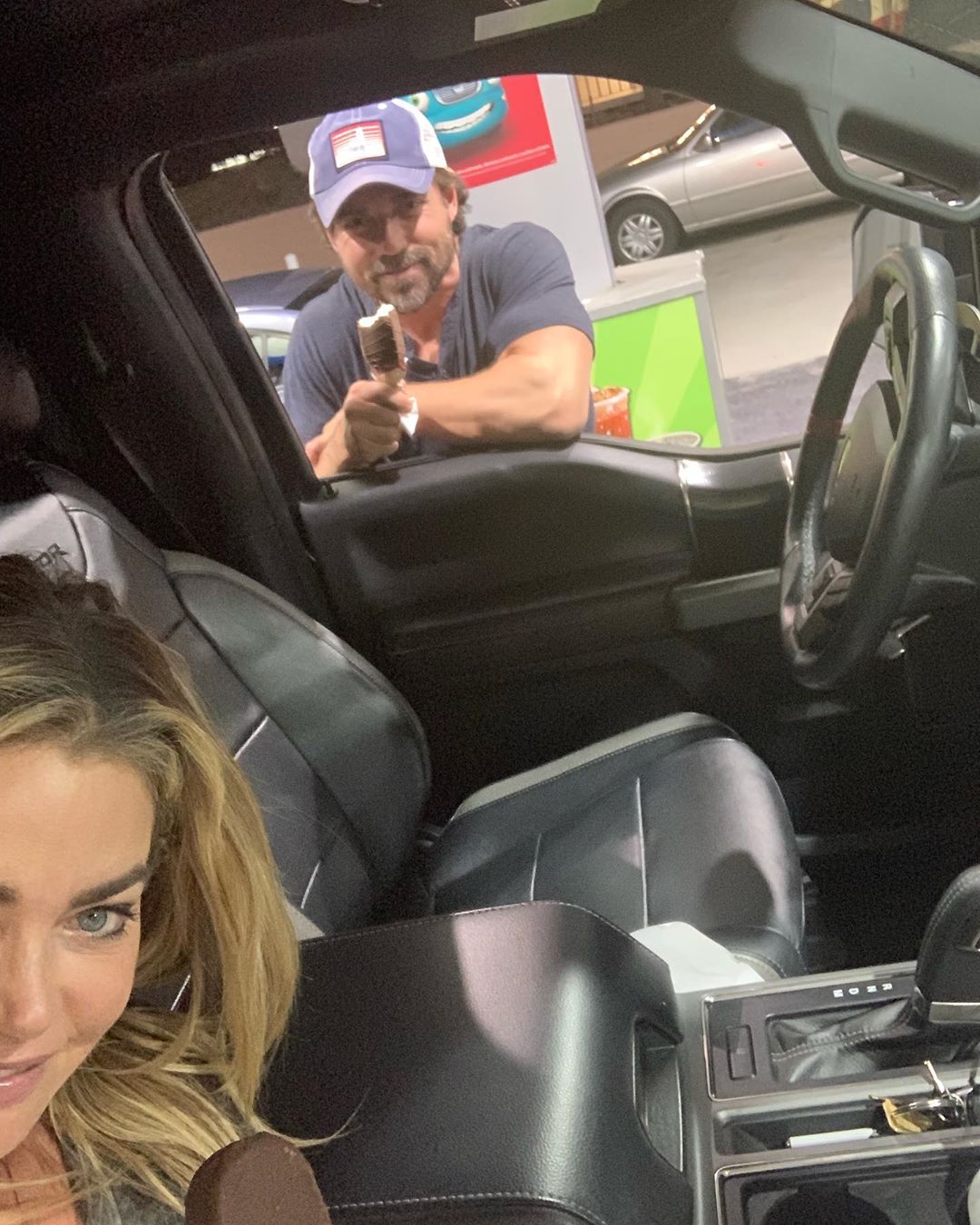 Denise Richard taking a selfie inside her black Cadillac Escalade with her husband Aaron Phypers.