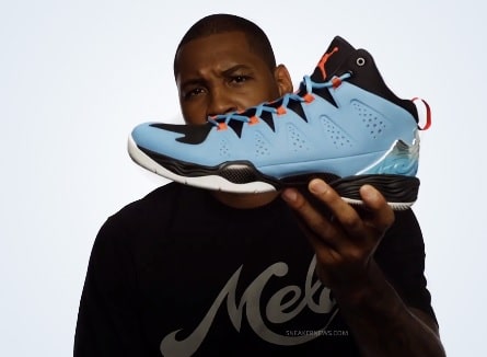 A picture of Carmelo Anthony holding his first signature Jordan shoe.