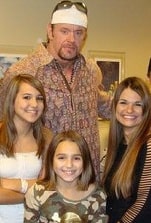 A picture of The Undertaker with his three daughters. 