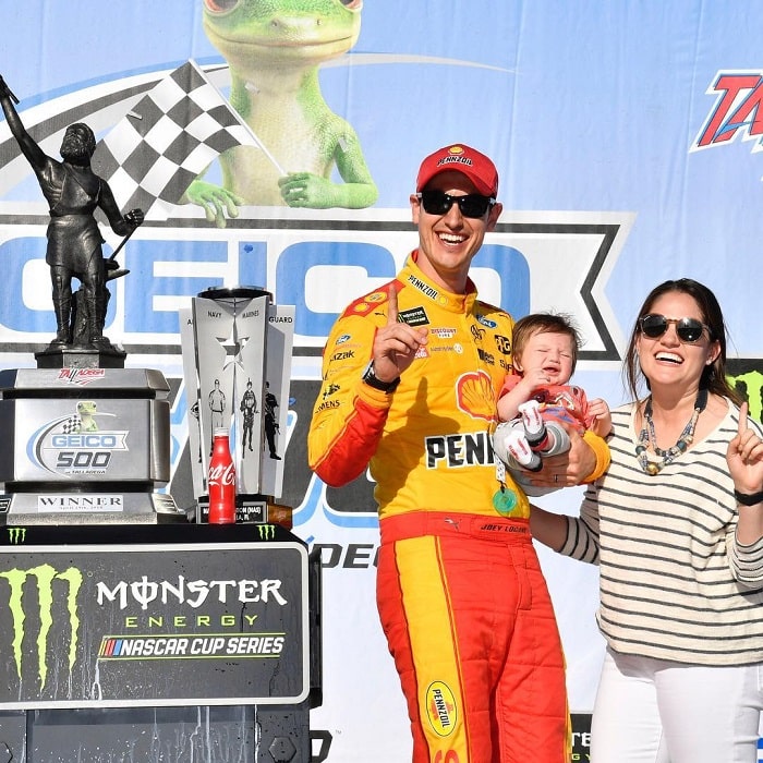 A picture of Logano celebrating his victory with his wife and son. 