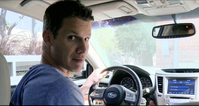 Daniel Tosh riding a Subaru Outback.