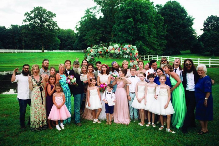 John family taking a group photo at his wedding ceremony.