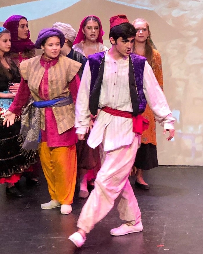 Kassius as Aladdin in a stage play.