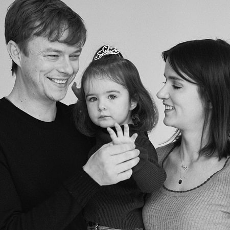 A picture of DeHaan family where Bowie Rose DeHaan is showing four finger where they soon will be four family members.