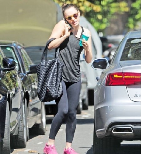 Daisy Ridley talking in phone while going inside her silver Audi A8.