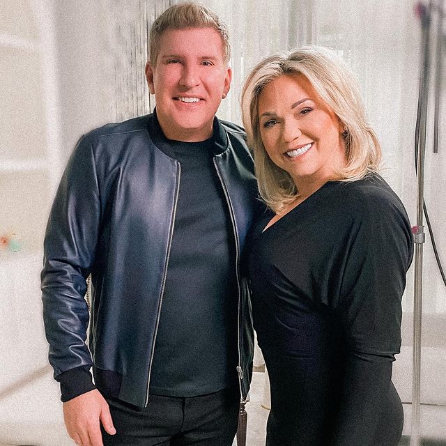 Todd wearing black tee and black jacket and his wife wearing black one piece.