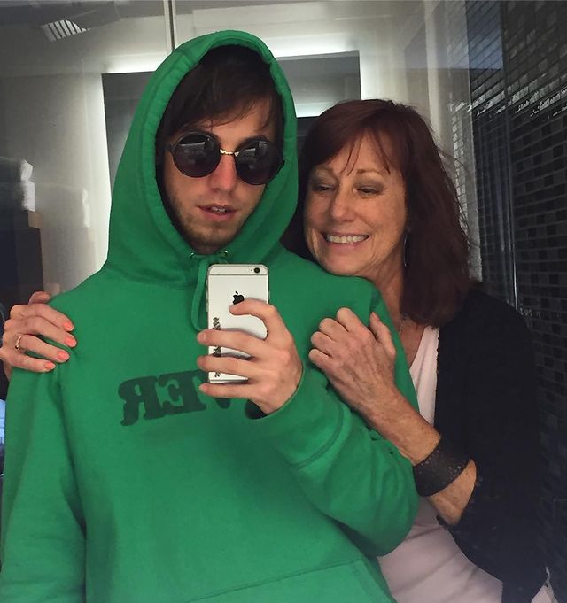 matt wearing green color hoodie and his mom wearing a black color outer and pink tee.