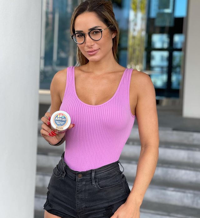 bru luccas wearing a pink top and black hot pant.