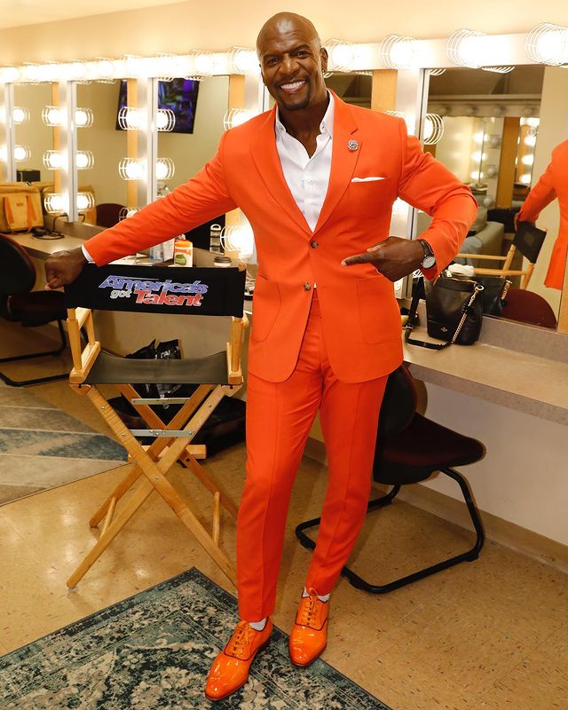 terry wearing orange suit with white shirt.