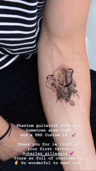 Charlie Gillespie showing off his tattoo on the owner of Phantom guitarist