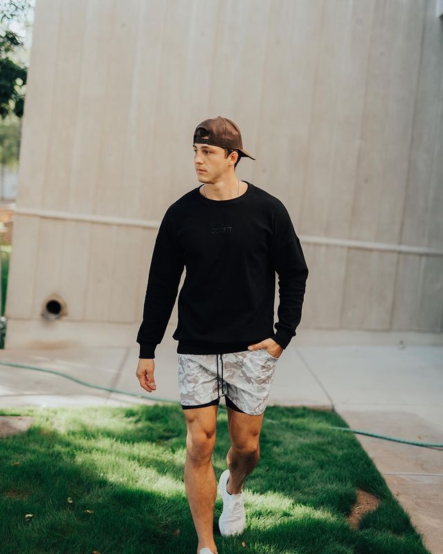 Josh wearing a black full tee and grey shorts.