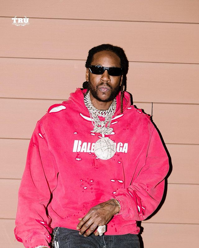 2 chainz wearing pink hoodie and black pant.