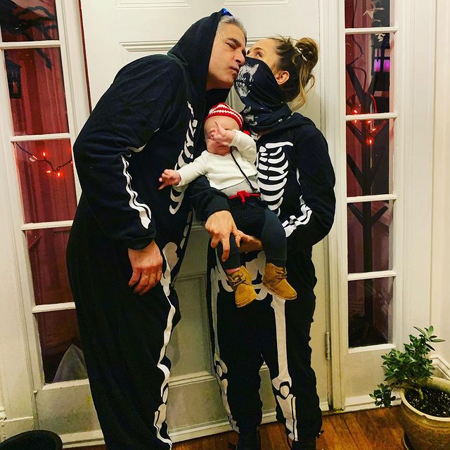 Peter Palandjian with his wife and child celebrating Halloween wearing a skeleton costume 