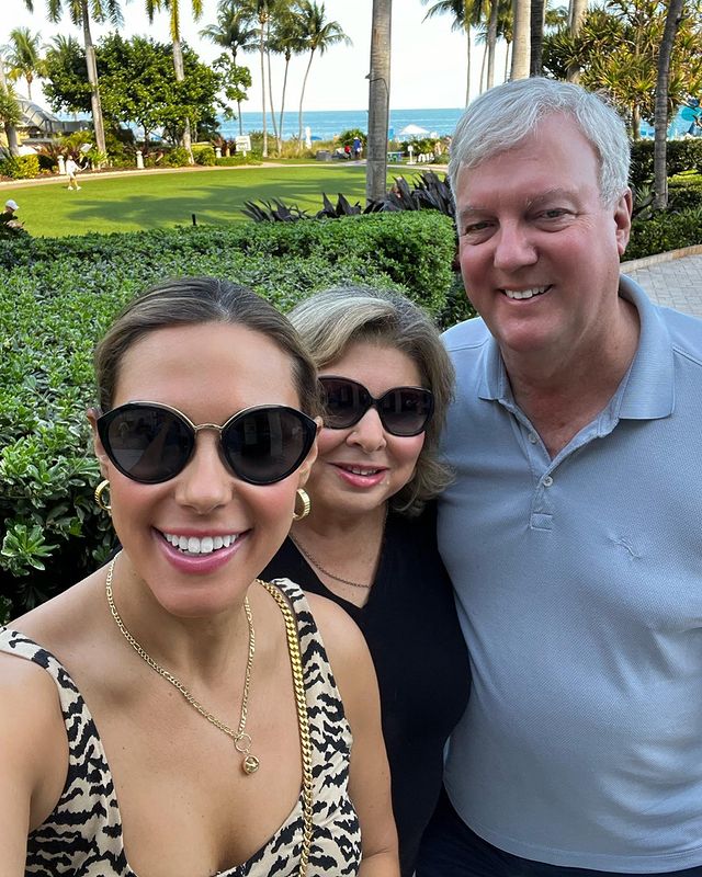 Lisa Boothe with her parents in a park wearing a sunglasses and a leopard printed crop top