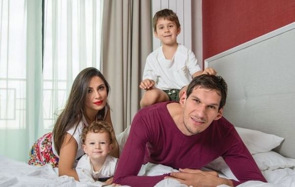 Boban  Marjanović with his family doing a photoshoot wearing a marron color t-shirt