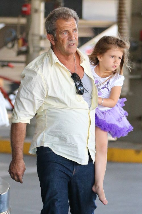 Lucia Gibson with her father Mel Gibson wearing a purple skirt 