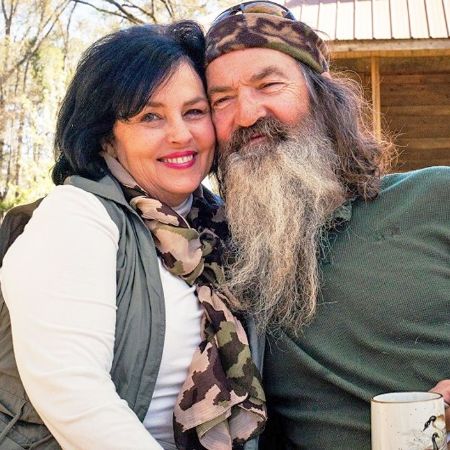 Robertson with his wife smiling together look happy.