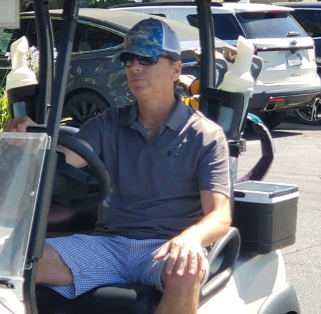 Photo of Scott Baio while riding golf cart. 