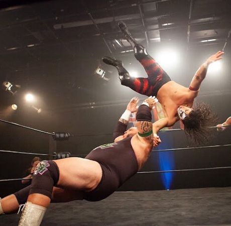 Tyrus posing wrestling with an opponent inside the ring. 