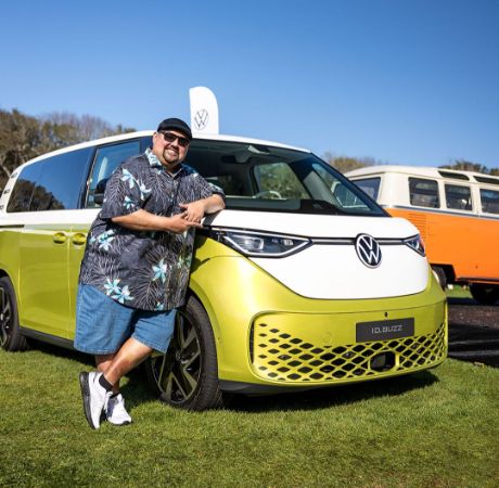 Gabriel Iglesias posing with his Volkswagen.
